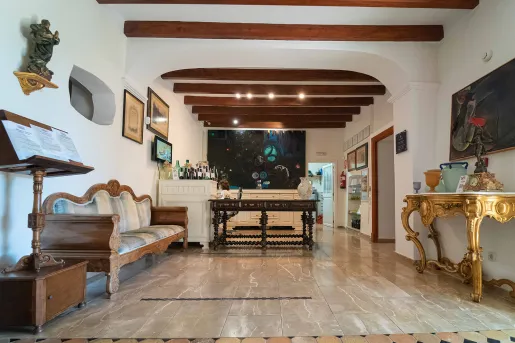 Indoor foyer and seating area with wooden furniture and paintings on the wall