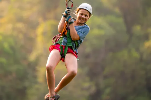 Girl smiling while riding on a zip line