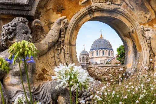 Stone statue with an hole looking towards a large church