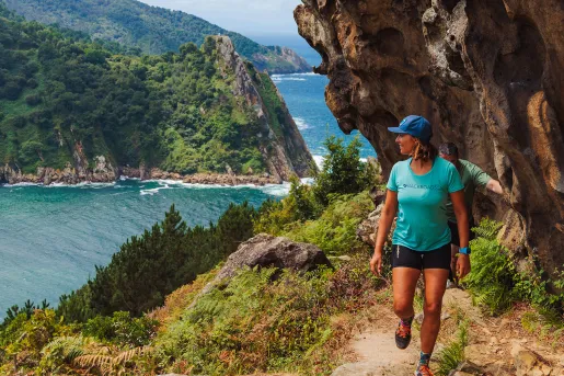 Woman hiking on a dirt trail with a river on the left