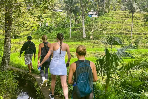 Group of women hiking towards an open valley of grass and plants