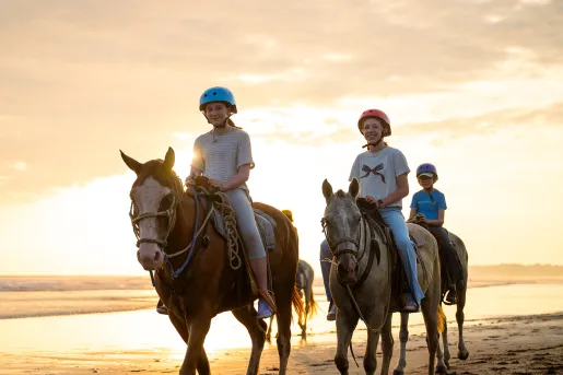 Group of teen girls smiling while horseback riding