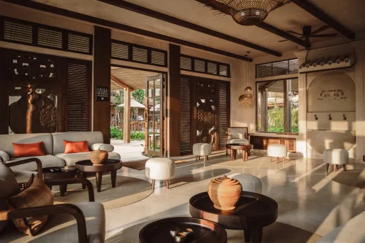 Hotel lobby room with cushioned, gray chairs and wooden walls