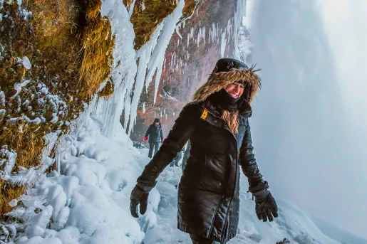 Woman wearing a snow jacket walking through a snowy path