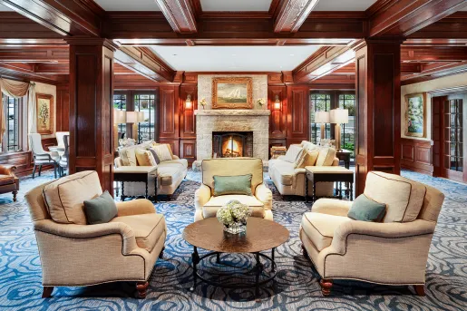 Hotel lobby with beige, cushioned chairs and large wooden pillars