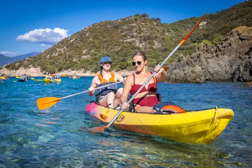 Two women paddling in a yellow kayak