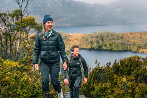 Man and woman ascending a staircase in the middle of a hill