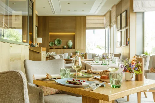 Dining room in a restaurant with plate of food and wine glasses on a table