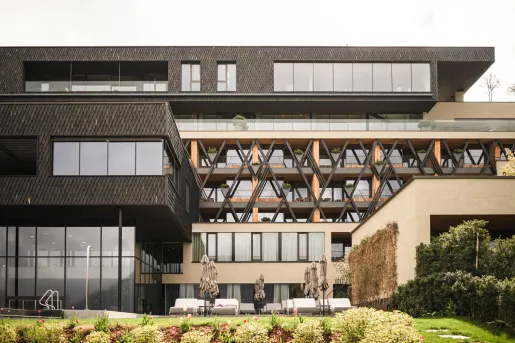 Exterior view of black and beige building complex with large windows and long balconies