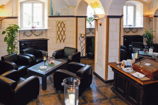 Hotel lobby with black, leather chairs around smaller coffee tables