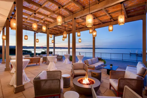 Outdoor patio and balcony with cushioned chairs surrounding fire pits