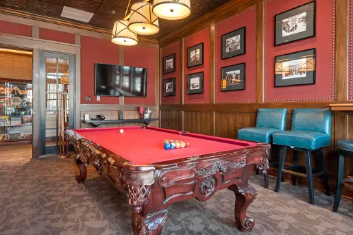 Room with a red pool table and pictures on the walls