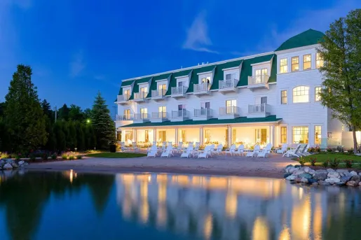 Exterior view of white and green hotel building with the beach in front