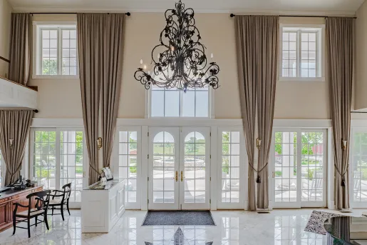 Hotel lobby with marble floors and large walls with windows