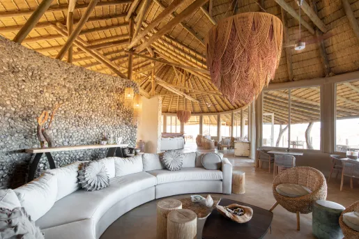Interior view of a hut with cushioned sofas and coffee tables