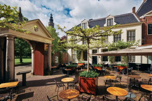 Outdoor patio with circular tables and black metal chairs