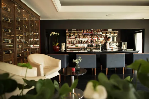 Bar and lounge with a bartender and shelves of alcohol along the walls