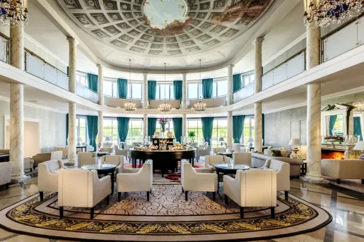 Large, open lounge area with cushioned chairs and large stone pillars