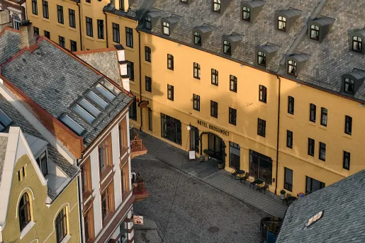 Exterior, sky view of an orange and black hotel building in the middle of a town center