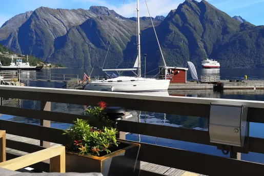 Dock with boats parked on the shore and mountains in the background