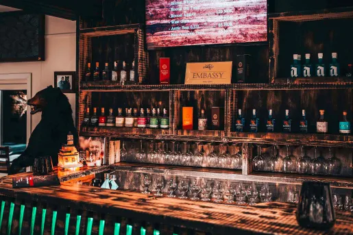 Bar and lounge with a counter and alcohol and spirits on the wall