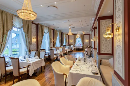 Dining hall with tables with linens and cushioned chairs