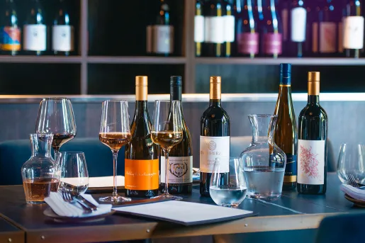 Row of wine bottles on top of a wooden table