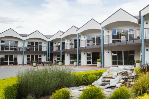 Exterior view of white hotel building with rooms and large windows