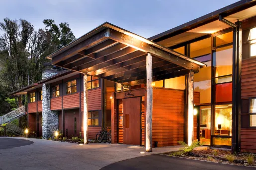 Exterior view of wooden hotel building with a tall wooden covering illuminated by lights