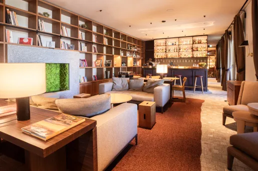 Bar and lounge with beige sofas and shelves full of books