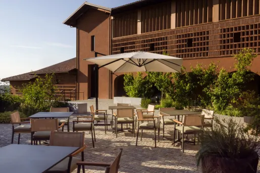 Outdoor dining area with cushioned chairs and square dining tables