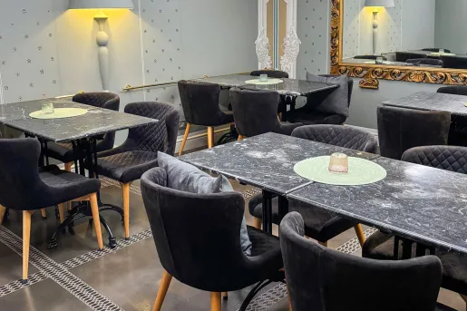 Dining hall with black tables and black cushioned chairs