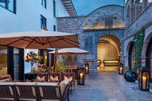 Outdoor patio with stone archways to the right and cushioned seats to the left