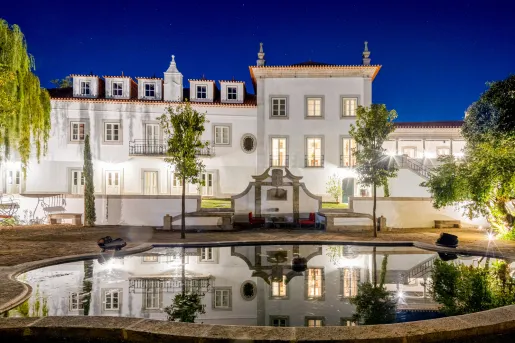 Exterior view of white building with with a fountain in front