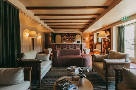 Indoor seating area and lounge with cushioned sofas and green curtains