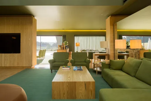 Seating area with green sofas and and wooden furniture