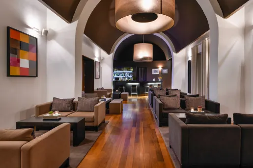 Long hallways with cushioned sofas and a bar at the end of the hallway