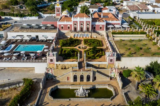 Sky view of hotel building with an outdoor garden and pool