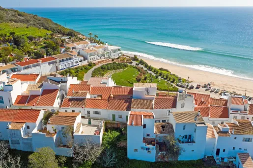 Sky view of white and brown houses next to the beach shore