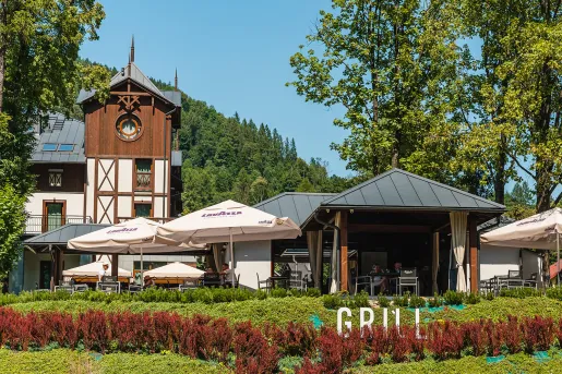 Outdoor patio with large umbrellas and trees surrounding the area