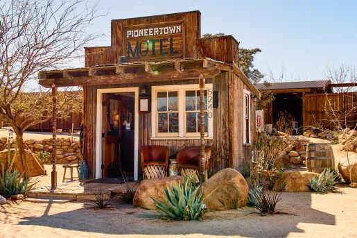 Exterior view of wooden motel entrance with a sign "Pioneertown Motel"