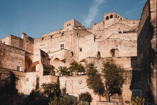 Stone building complex with small trees surrounding