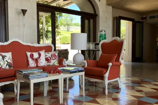 Indoor lobby with patterned floor and cushioned, red chairs