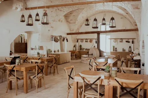 Indoor dining area with wooden chairs and tables with large wooden pillars in the back