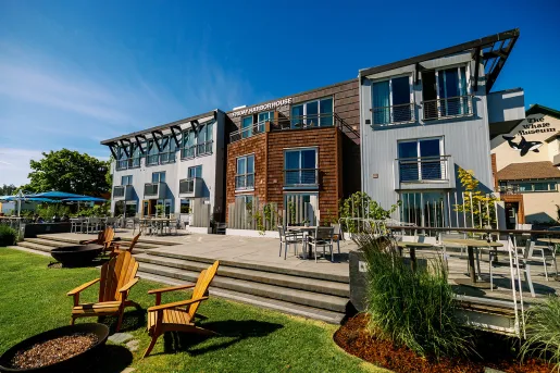 Exterior view of wood and metal hotel building, with a stone patio and large grass area