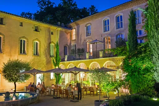 Outdoor patio with dining tables illuminated with warm lights