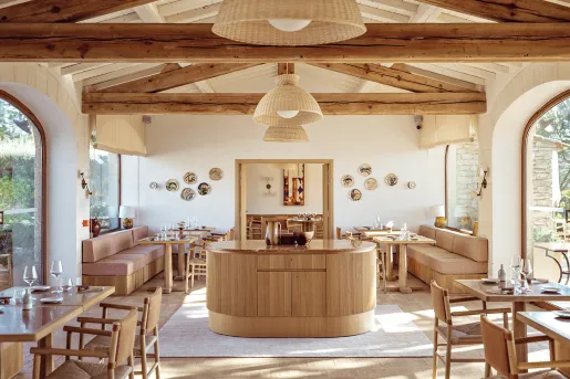 Dining table with cushioned sofas and wooden pillars