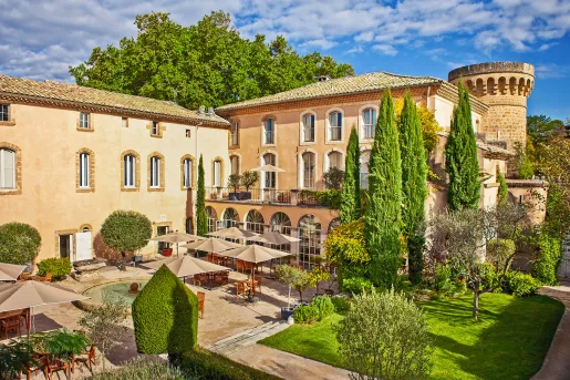 Exterior view of tan colored, stone building with a small garden in front