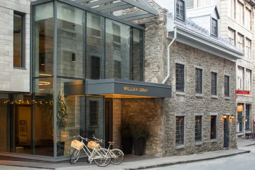 Exterior view of stone hotel building with a gray "Willian Gray" sign
