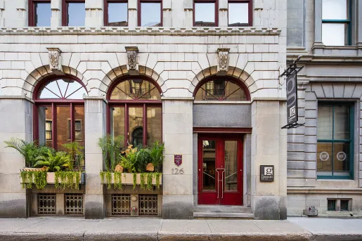 White stone building entrance with a red door